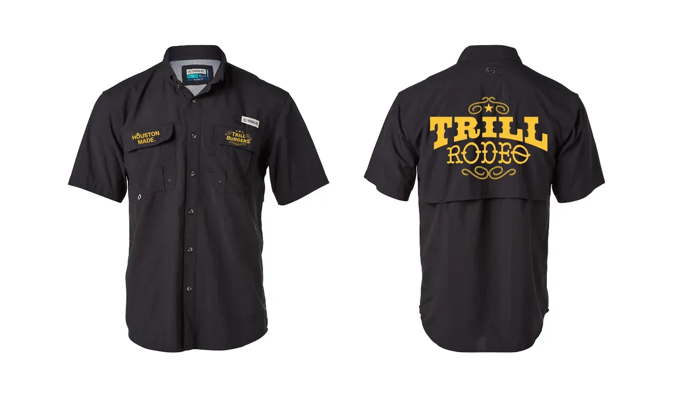 Front and back views of a black short sleeve button up shirt on a white background. The front has two flap chest pockets, gold Houston Made type with a cowboy hat on the left pocket and a gold Trill Burgers rope lockup with three stars on the right pocket, plus a small white brand tag reading Magellan above the right pocket and a Magellan label inside the collar. The back has a large gold Trill Rodeo lockup with a star and rope flourishes, above a caped back panel.
